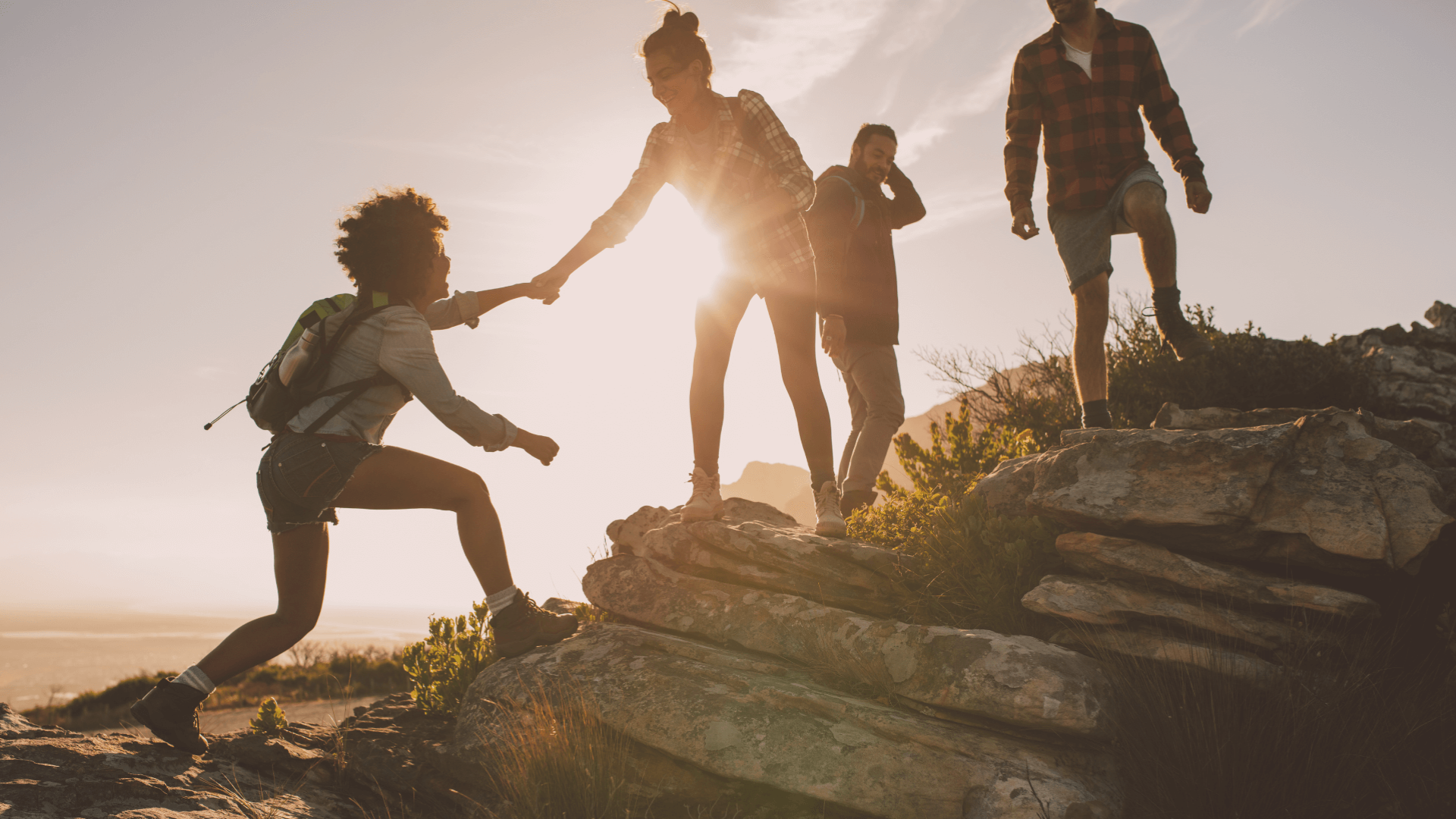 Girl giving hand to another girl to climb